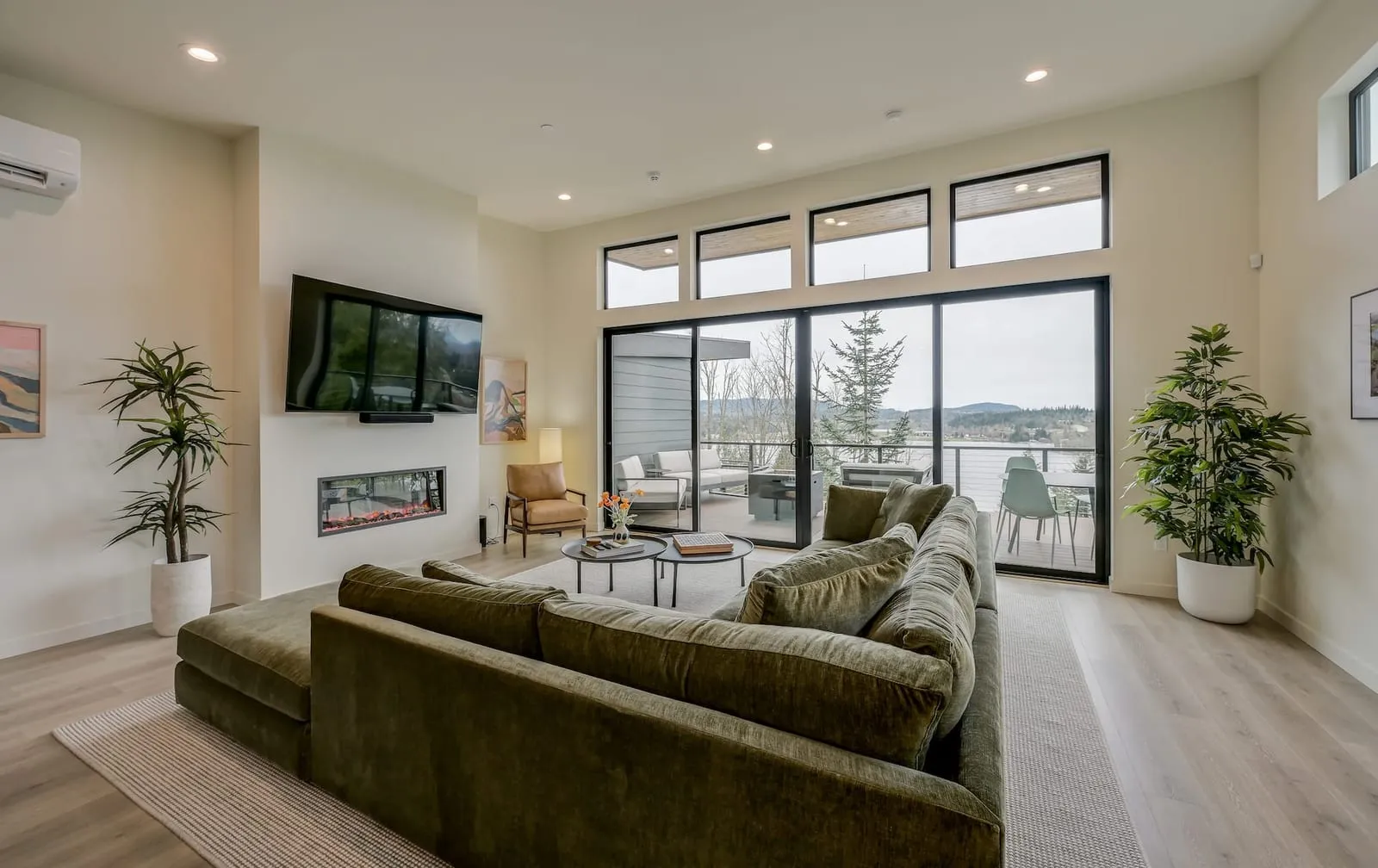 The living room of the 1-bedroom cabin, with a wall of glass over the valley